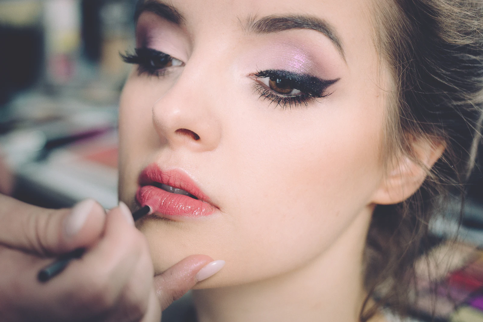 Primo piano dell'applicazione di un rossetto durante un trucco professionale